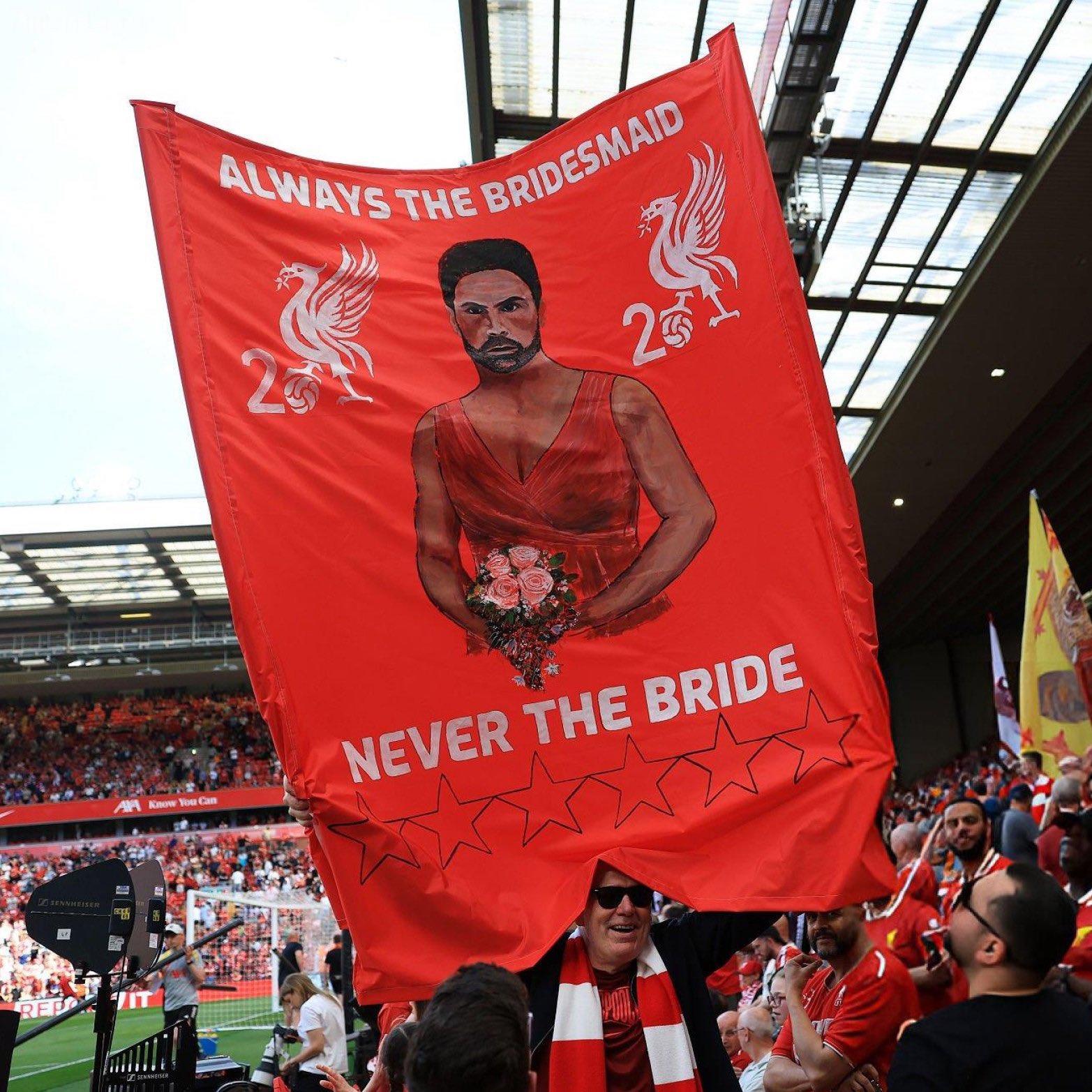 Người hâm mộ Liverpool giương cao biểu ngữ chế giễu Arteta vì đội của anh không giành được bất kỳ danh hiệu lớn nào trong bốn danh hiệu lớn: Tôi luôn là phù dâu, không bao giờ là cô dâu