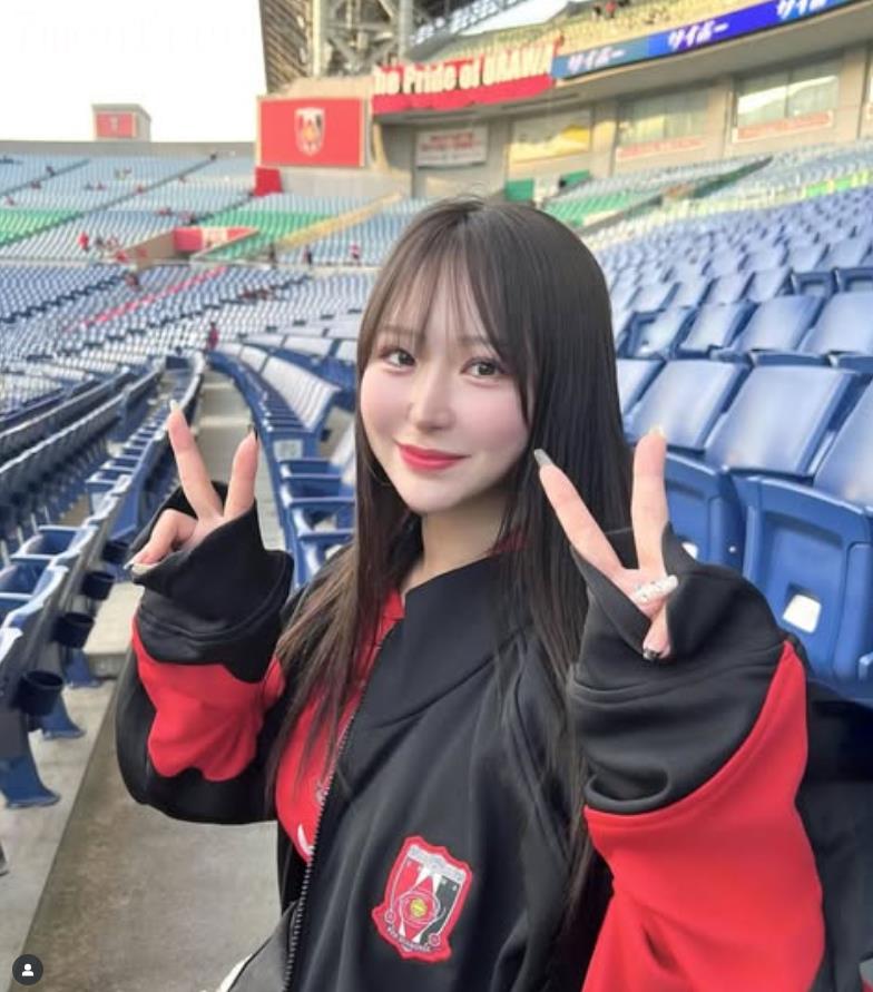 Fan nữ Urawa đây rồi! Gương mặt đỏ bừng mỉm cười dưới ánh hoàng hôn, mái tóc đen lay động trong gió, vòng eo thon thả.