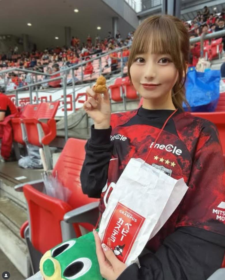 Fan nữ Urawa đây rồi! Gương mặt đỏ bừng mỉm cười dưới ánh hoàng hôn, mái tóc đen lay động trong gió, vòng eo thon thả.